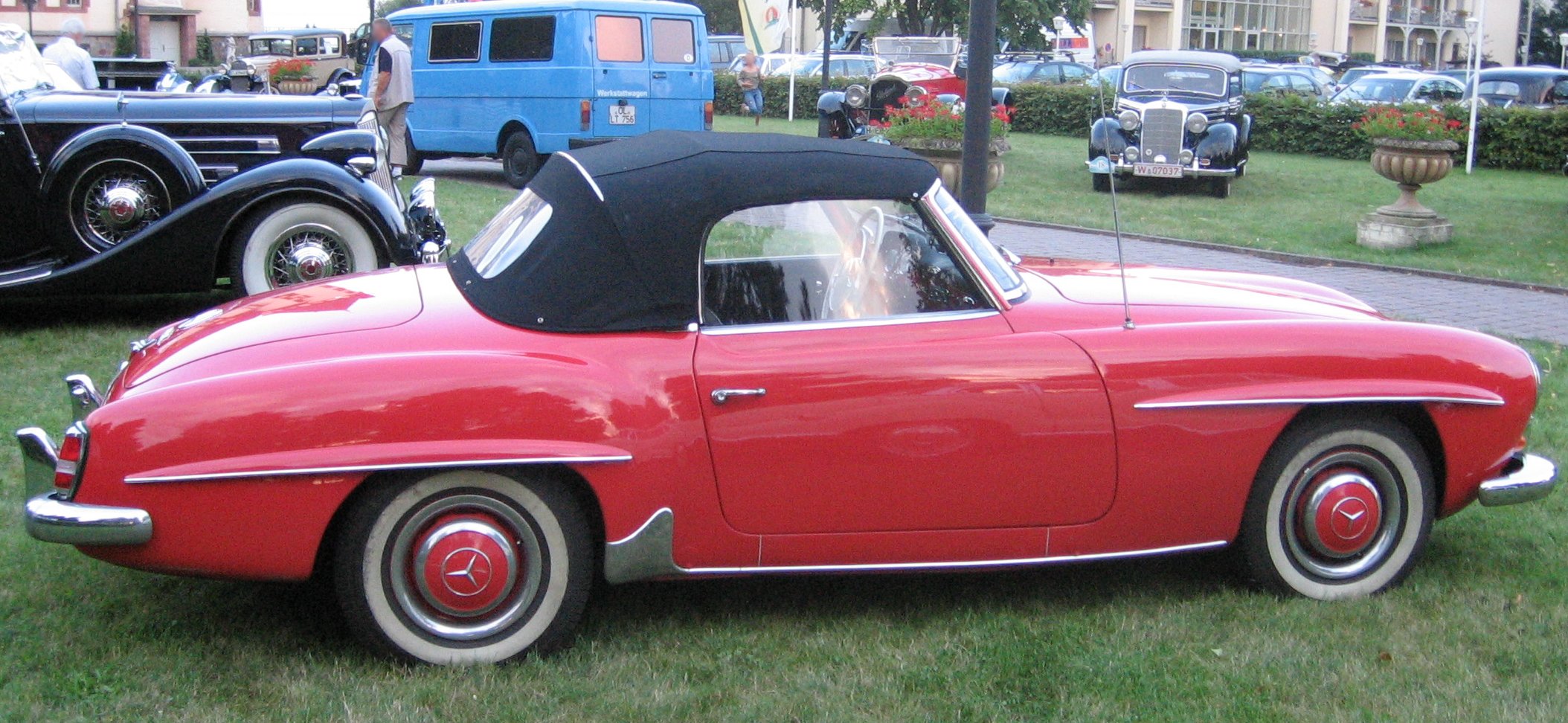 Rød Mercedes-Benz 190 SL med sort kaleche fotograferet fra siden
