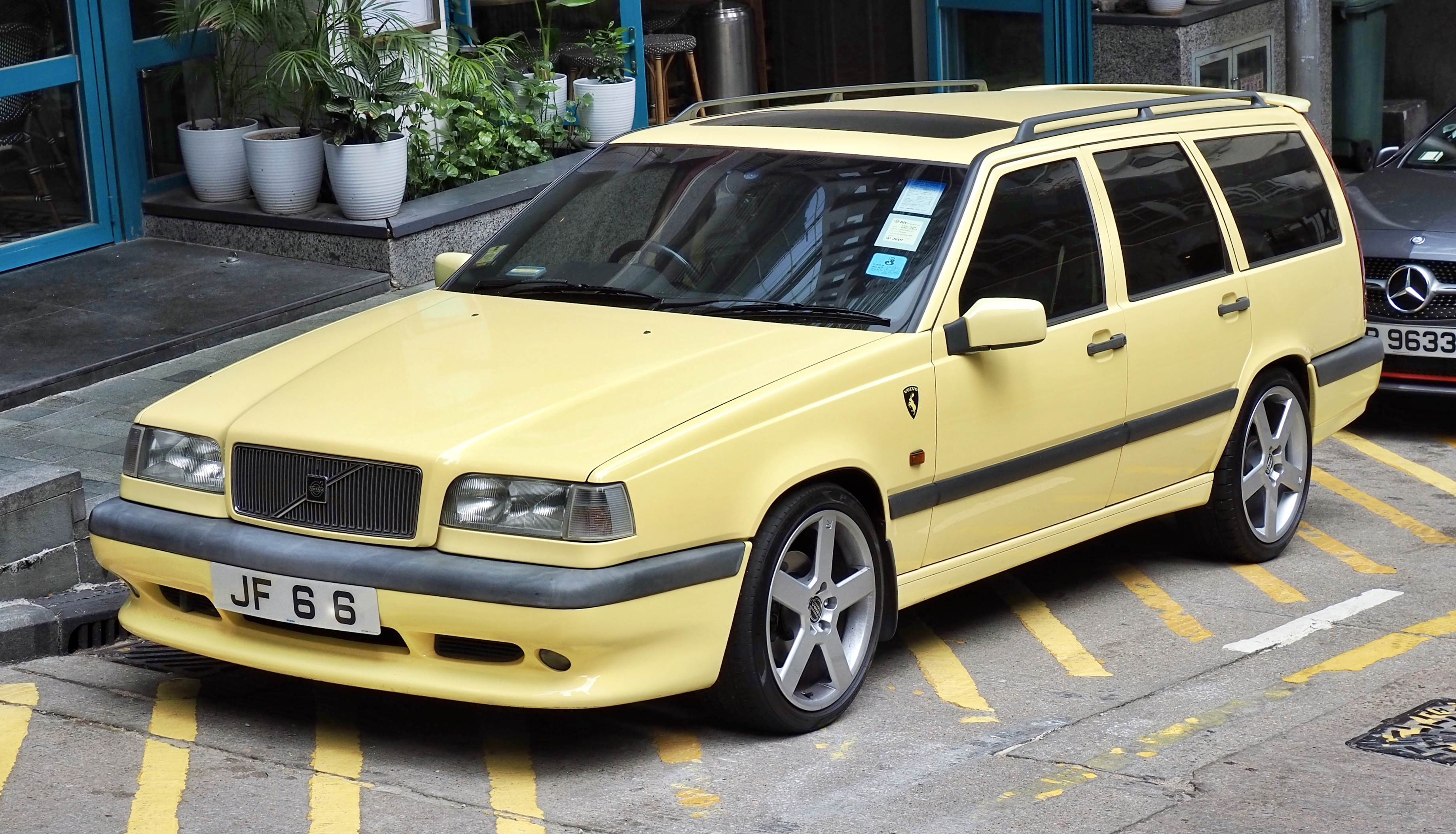 Gul Volvo 850 T-5R stationcar fra 1995 set skråt forfra