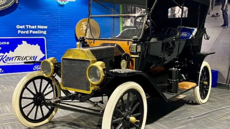 Ford Model T med åbent karrosseri, messingfarvede lygter og lyse dæksider.