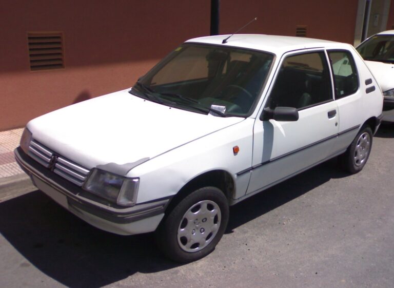 Hvid Peugeot 205 hatchback fotograferet fra siden og skråt forfra